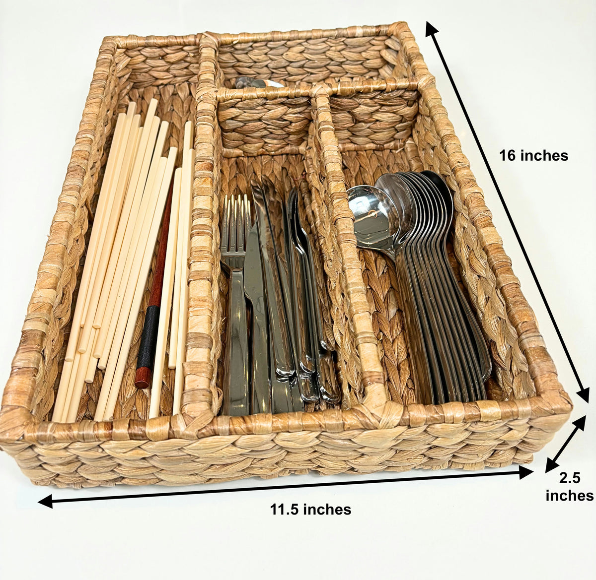 A handwoven water hyacinth cutlery and drawer organizer filled with various utensils, measuring 16 inches in length, 11.5 inches in width, and 2.